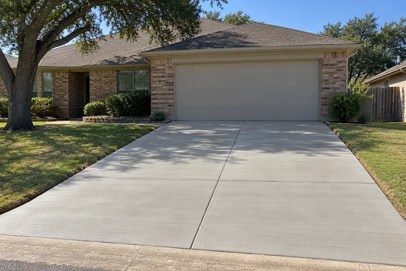 Broom-finished two-car concrete driveway with saw-cut control joints