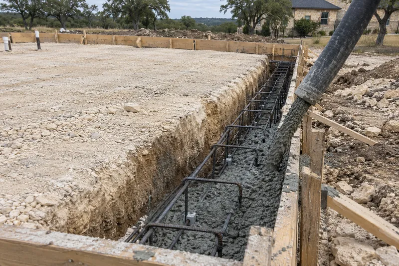 Concrete placed into grade beams from a pump hose