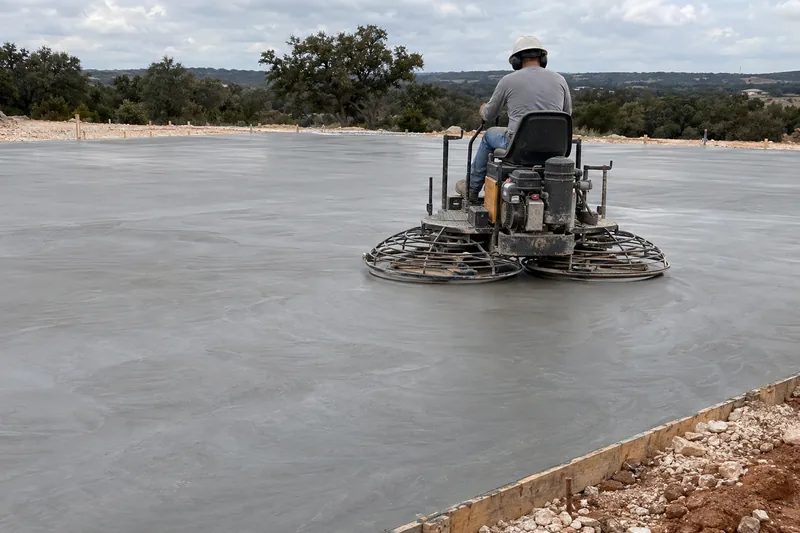 Ride-on power trowel finishing a large concrete slab