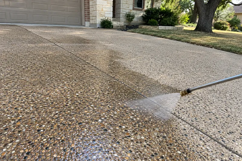 A sprayer applying clear sealer to an exposed-aggregate driveway